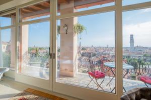 ヴェローナにあるRelais Colle San Pietroの市街の景色を望むガラスのスライドドア付きの客室です。