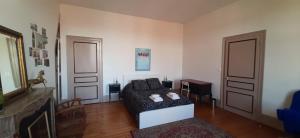 a living room with a couch and two doors at La Belle Boulonnaise in Boulogne-sur-Mer