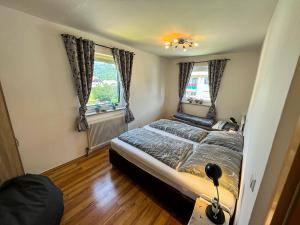 ein Schlafzimmer mit einem Bett und zwei Fenstern in der Unterkunft Ottl's Appartement mit Kreischbergblick O1 in Sankt Lorenzen ob Murau