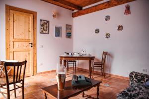 salon ze stołem, krzesłami i drzwiami w obiekcie Bobo House Calasetta w mieście Calasetta