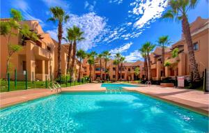 uma piscina com palmeiras e casas em Lovely Apartment In Los Alczares With Kitchen em Los Alcázares