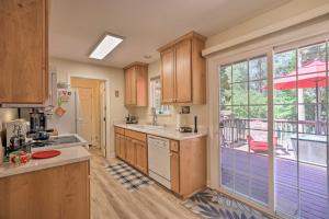 une cuisine avec des placards en bois et une grande fenêtre dans l'établissement Pollock Pines Apartment with Private Deck on 5 Acres, à Pollock Pines