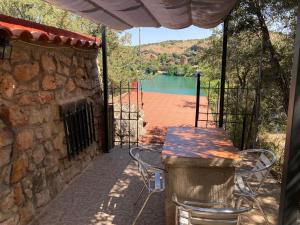 una mesa y sillas en un patio con vistas al lago en La Buena Siesta, en Ruidera
