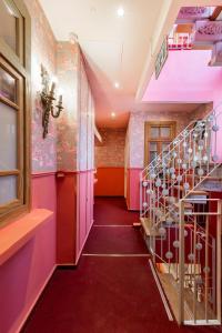 a hallway with a staircase in a building with pink walls at The Elliot - Adults only in Tel Aviv