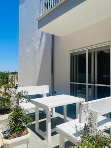 un tavolo bianco e delle panche su un balcone di La casa di Nina a Lecce
