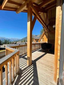 a wooden deck with a table and chairs on it at Chalet de 5 chambres avec sauna jardin clos et wifi a Les Orres in Les Orres