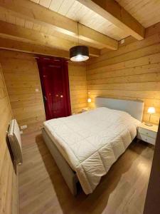 a bedroom with a bed in a wooden room at Chalet de 5 chambres avec sauna jardin clos et wifi a Les Orres in Les Orres