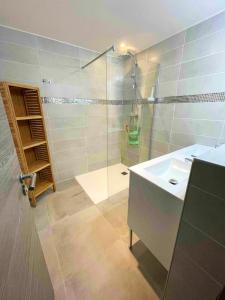 uma casa de banho com um chuveiro, um lavatório e uma cabina de duche em vidro. em Chalet de 5 chambres avec sauna jardin clos et wifi a Les Orres em Les Orres