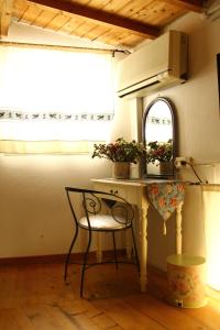 einen Tisch und einen Stuhl in einem Zimmer mit Fenster in der Unterkunft Bed And Breakfast Majore in Nuoro