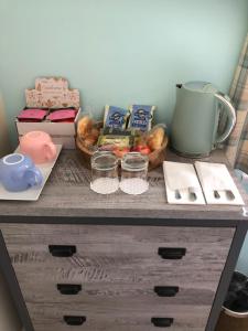 a table with a basket of food and a coffee maker at Brighton Surf Guest House in Brighton & Hove