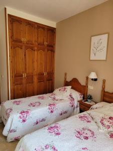 巴魯耶拉的住宿－Allotjament rural Casa Milagros，一间卧室设有两张床和木制橱柜