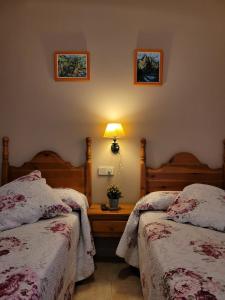 um quarto com duas camas e um candeeiro sobre uma mesa em Allotjament rural Casa Milagros em Barruera