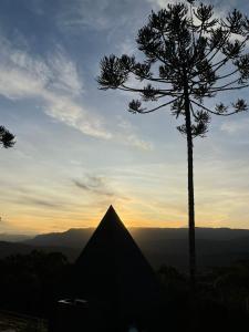 una silueta de una pirámide y un árbol al atardecer en Cabanas Cold Mountain, en Urubici
