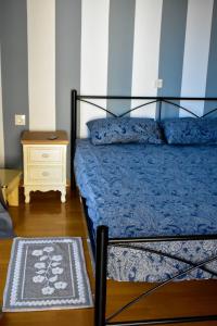 a bedroom with a bed with a blue comforter and a table at Downtown Apartment Karystos in Karistos