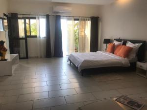 sypialnia z łóżkiem z pomarańczowymi poduszkami w obiekcie Residence Awale Abidjan w mieście Cocody