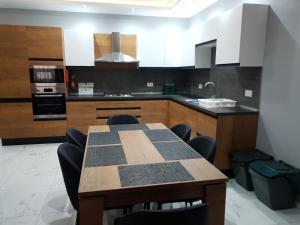 a kitchen with a table with chairs and a sink at A Ground Floor Maisonette - Mellieha Bay in Is-Sellum