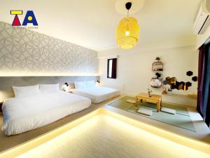 1 dormitorio con 2 camas y mesa en Ta 溫泉會館, en Jiaoxi