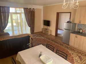 a living room with a table and a refrigerator at Берег in Bosteri