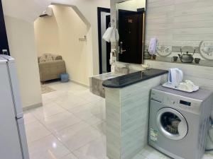 a laundry room with a washing machine and a mirror at برادايز للاجنحة المخدومة in Khamis Mushayt