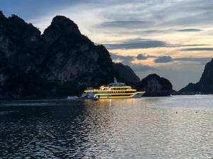 a boat in the water with mountains in the background at Mon Homestay Hạ Long in Ha Long