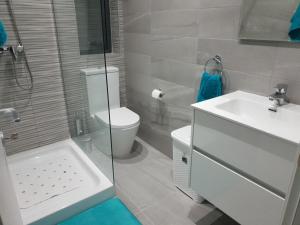a bathroom with a toilet and a sink and a shower at A Ground Floor Maisonette - Mellieha Bay in Is-Sellum
