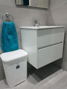 a bathroom with a white sink and a trash can at A Ground Floor Maisonette - Mellieha Bay in Is-Sellum +26 photos
