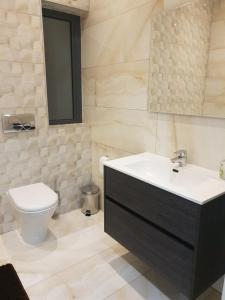 a bathroom with a sink and a toilet at A Ground Floor Maisonette - Mellieha Bay in Is-Sellum