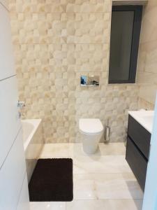 a bathroom with a toilet and a sink and a mirror at A Ground Floor Maisonette - Mellieha Bay in Is-Sellum