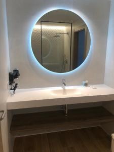 a bathroom with a sink and a round mirror at HOTEL MONTE PERDIDO in Bielsa