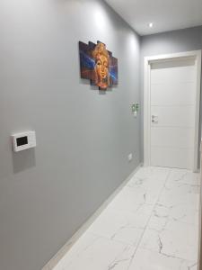 a white room with a painting on the wall at A Ground Floor Maisonette - Mellieha Bay in Is-Sellum
