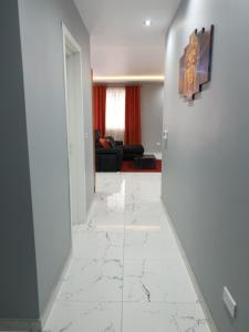 a hallway with a white tile floor and a living room at A Ground Floor Maisonette - Mellieha Bay in Is-Sellum