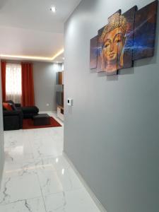 a living room with a large painting on the wall at A Ground Floor Maisonette - Mellieha Bay in Is-Sellum