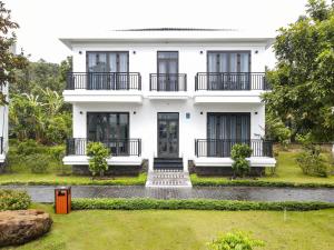 a white house with black windows and a yard at DAD Resort Phú Quốc in Phú Quốc