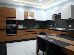 a kitchen with wooden cabinets and a table with chairs at A Ground Floor Maisonette - Mellieha Bay in Is-Sellum
