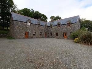 an old stone house with a large driveway at Clós Na Feirme in Galway