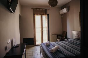 a bedroom with a bed and a large window at Le Antiche Colonne in Cinquefrondi