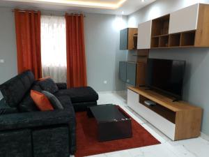 a living room with a couch and a flat screen tv at A Ground Floor Maisonette - Mellieha Bay in Is-Sellum