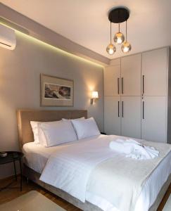 een slaapkamer met een groot bed met witte lakens bij Filoxenia Luxury Home Ioannina in Ioannina