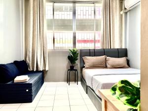 曼谷的住宿－My Home N1 - BTS Ratchathewi，一间卧室设有两张床、一张沙发和一个窗口
