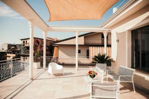 patio z białymi krzesłami i stołami na balkonie w obiekcie Le Antiche Colonne w mieście Cinquefrondi