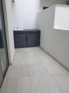 a white room with a tiled floor and a counter at A Ground Floor Maisonette - Mellieha Bay in Is-Sellum