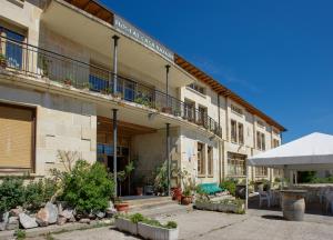 an apartment building with a courtyard with plants and a patio at Hostal Casa Ramón in Quintanar de la Sierra