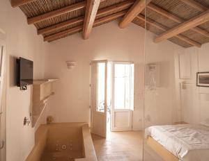 Habitación blanca con cama y ventana en Iardino Asce Lisària, en Zollino