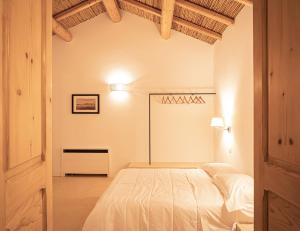 1 dormitorio con 1 cama blanca en una habitación en Iardino Asce Lisària, en Zollino