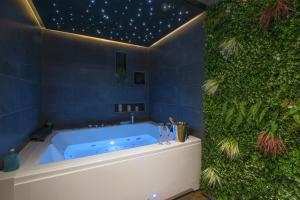 a bathroom with a blue tub with a green wall at Lorient Love Room Le King Size in Lorient