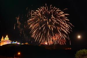 a fireworks display with a castle in the background at A Ground Floor Maisonette - Mellieha Bay in Is-Sellum