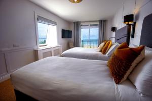 a hotel room with two beds and two windows at The Cliff House Hotel in Ballybunion