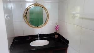 een badkamer met een wastafel en een spiegel bij Pousada Solar Maia Costa in Atins
