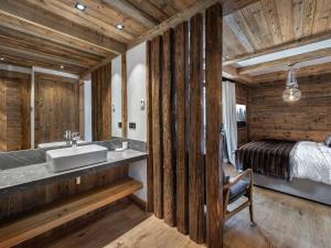 Un baño con lavabo y una cama en una habitación. en Chalet luxueux avec 5 chambres, hammam, cheminée et grande terrasse au cœur de Val d'Isère - FR-1-567-34, en Val dʼIsère