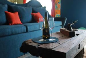 een tafel met een fles wijn en twee glazen erop bij Mourne Mountain Art Apartments in Newcastle